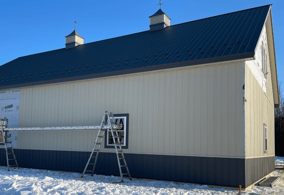 Side view of a building under construction with ladders leaning against the wall.