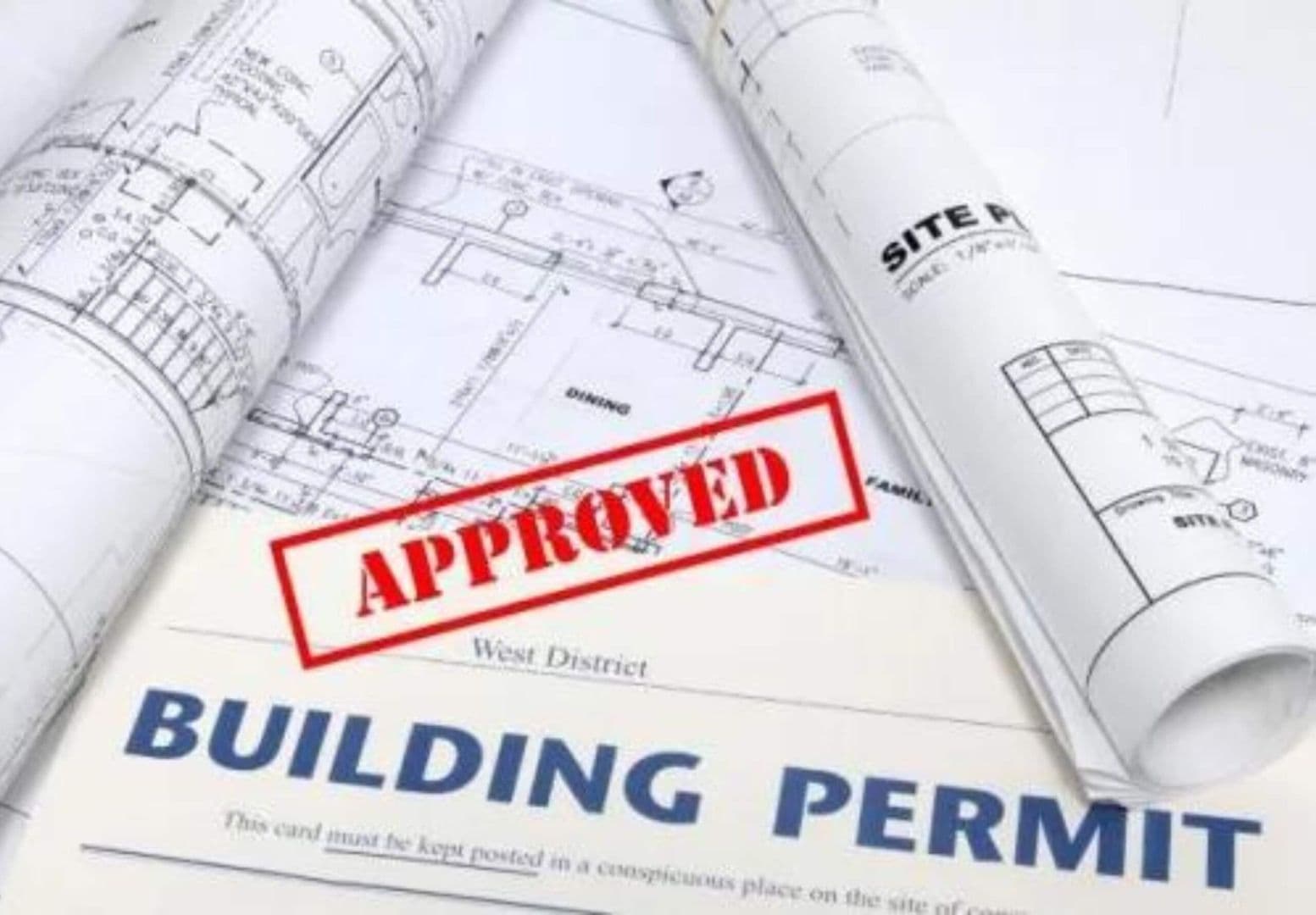 Building permit paperwork with an "Approved" stamp superimposed.