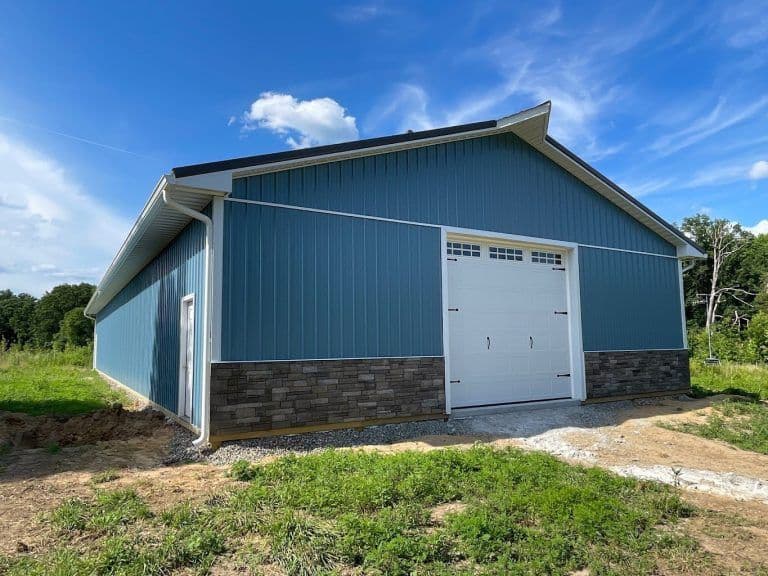 A post frame building with faux stone wainscoating.
