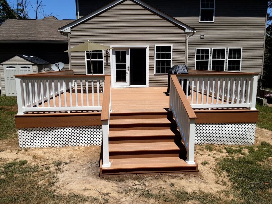 A new brown deck with white and brown railings.