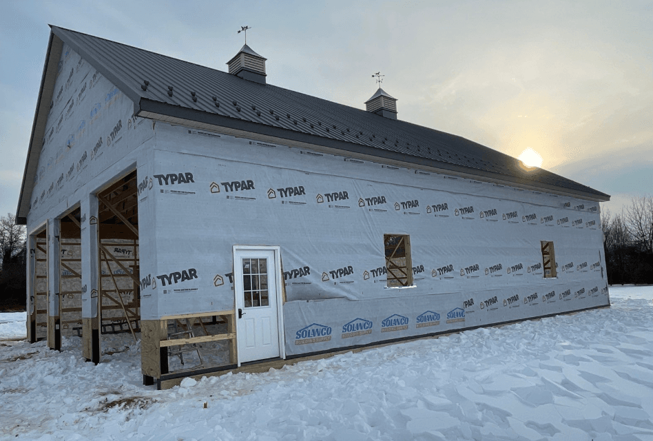 Building under construction with a door framed and covered in Typar wrapping