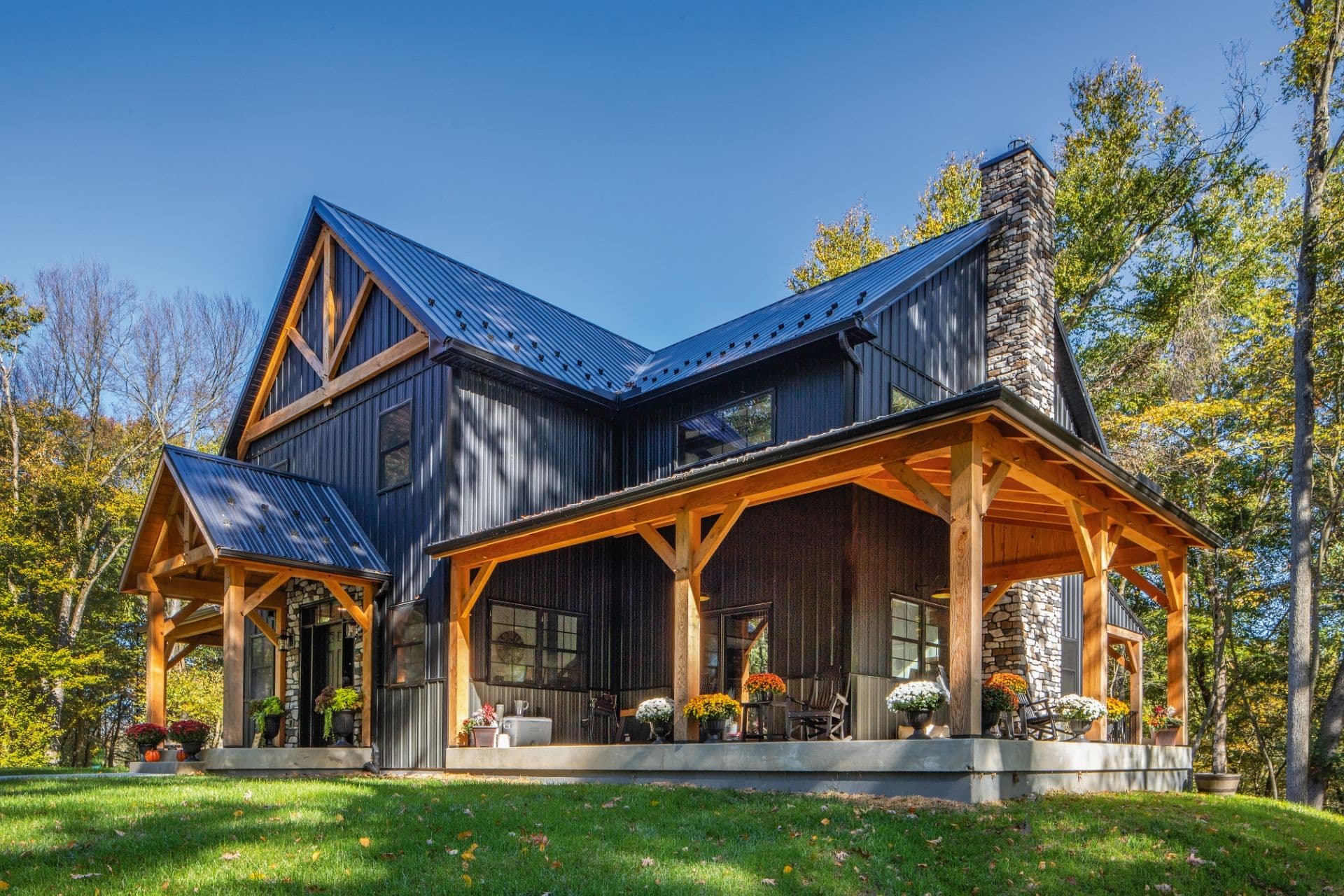 A black new construction barndominium with light brown wood accents.