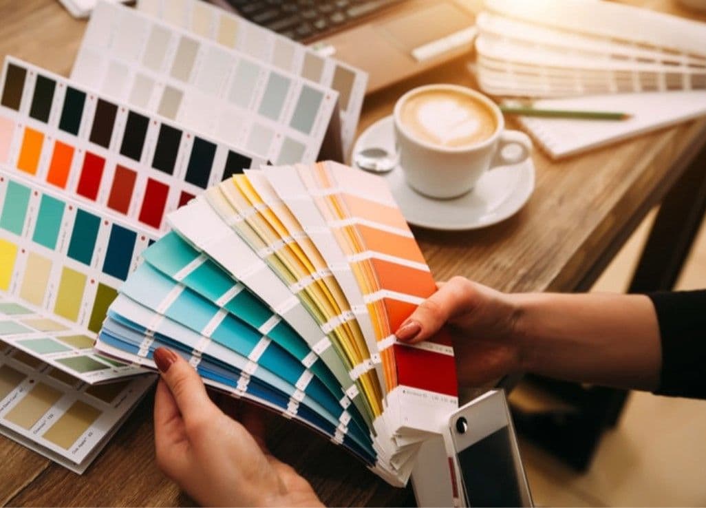 A person holds a booklet of color swatches.