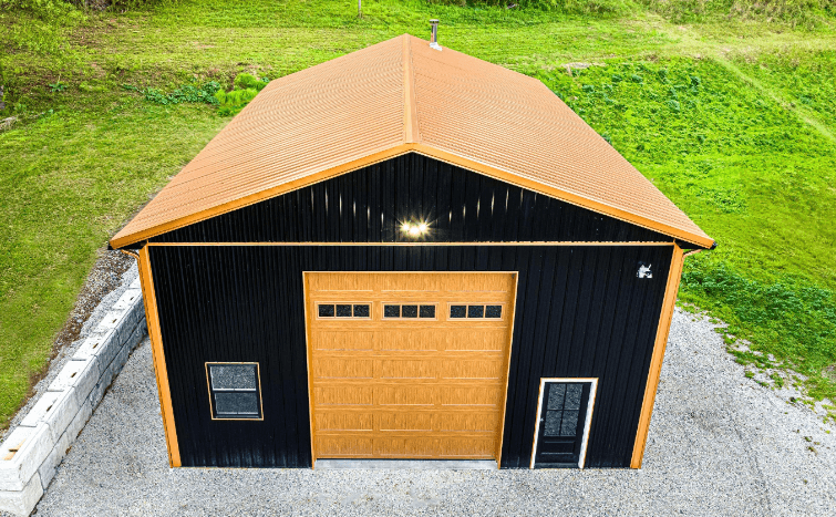A black garage with light brown door and roof.