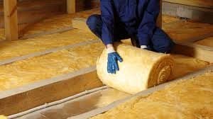 A worker installs insulation.