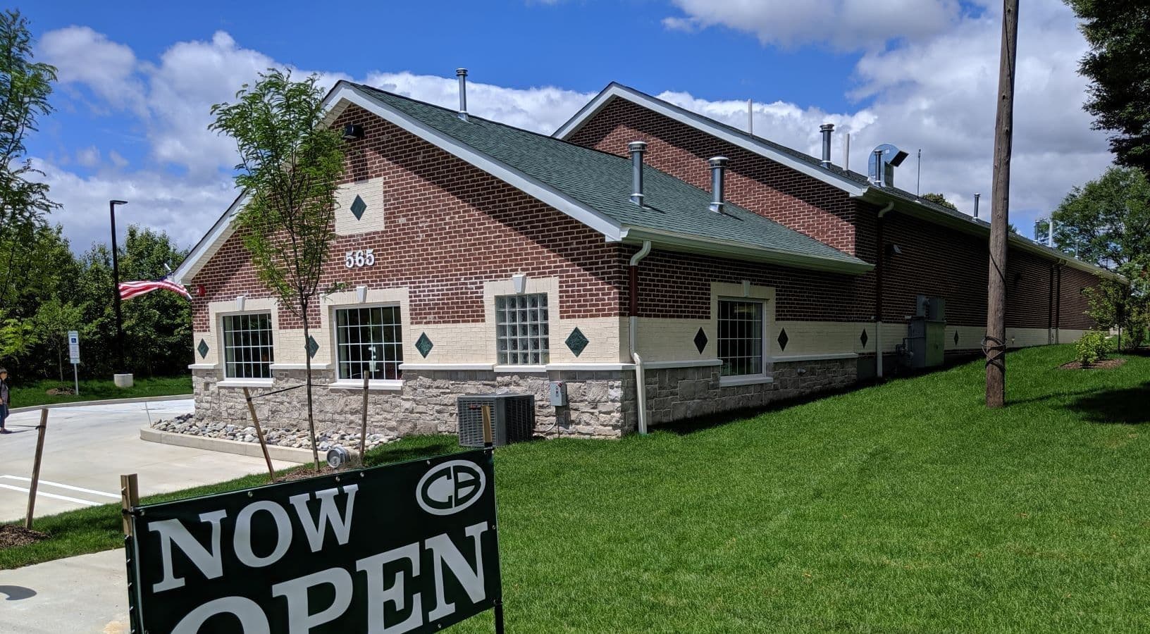 A red and white brick and stone building with light gray asphalt shingle roof.