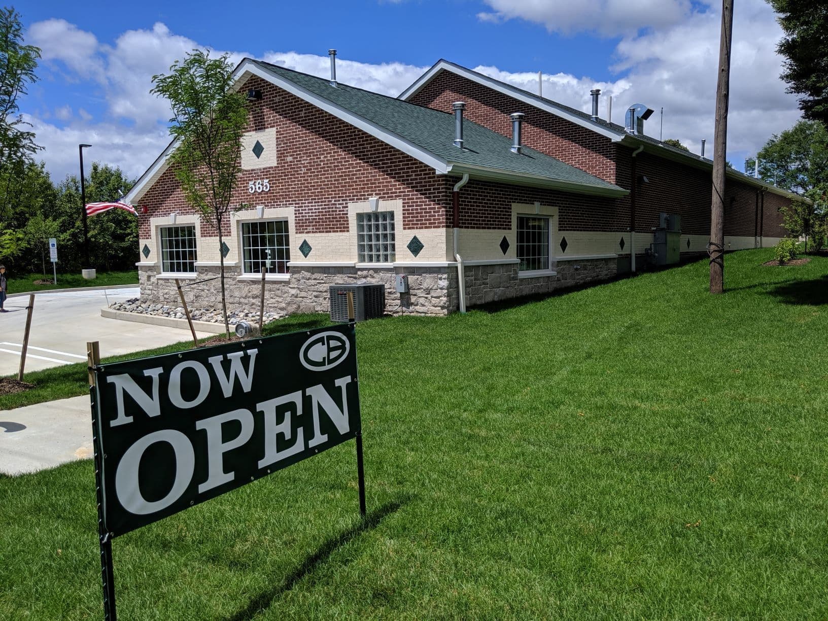 A red and white brick and stone building with light gray asphalt shingle roof.