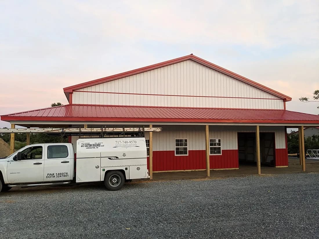 A red and white pole barn building with red metal roof.