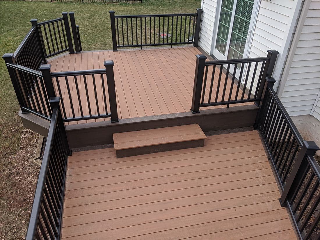 A brown deck with black metal railings and trim.