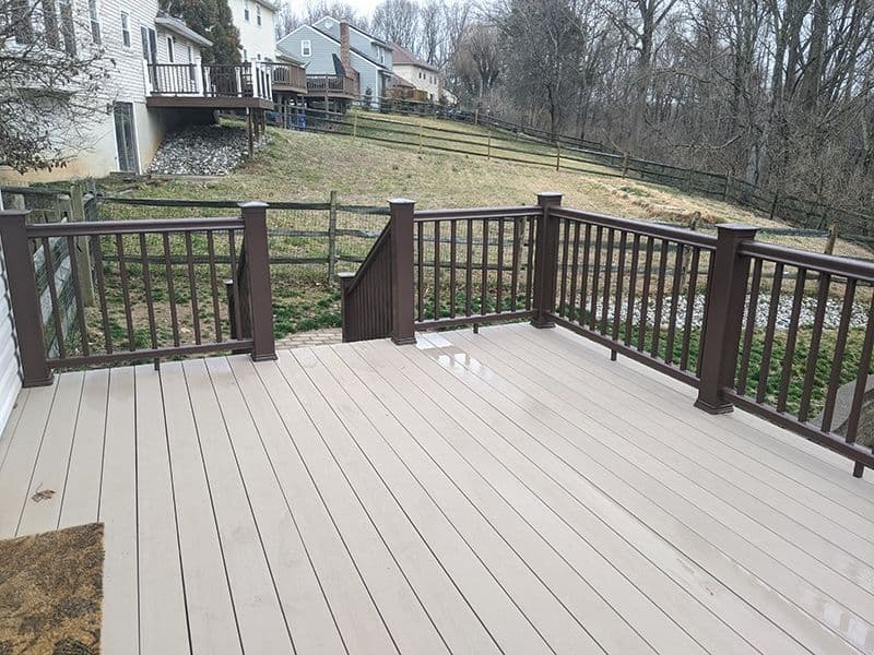 A light gray deck with dark brown railing.