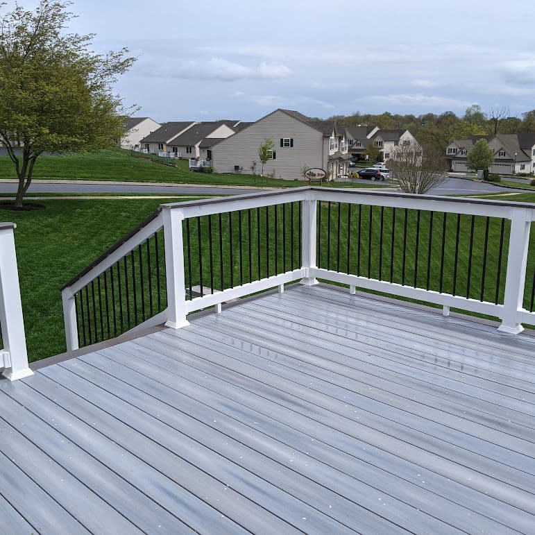 A light gray deck with white and black railing.