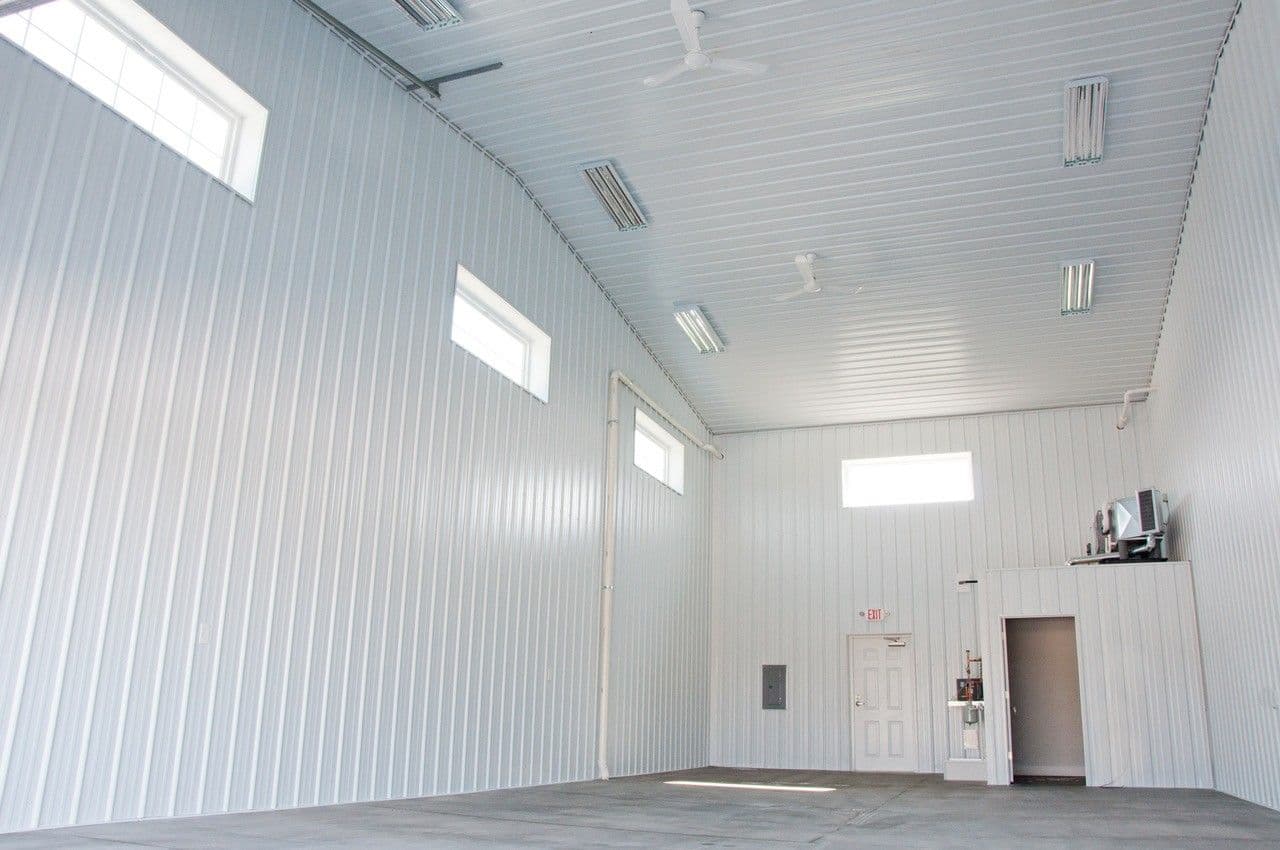 A post frame building with a white metal interior.
