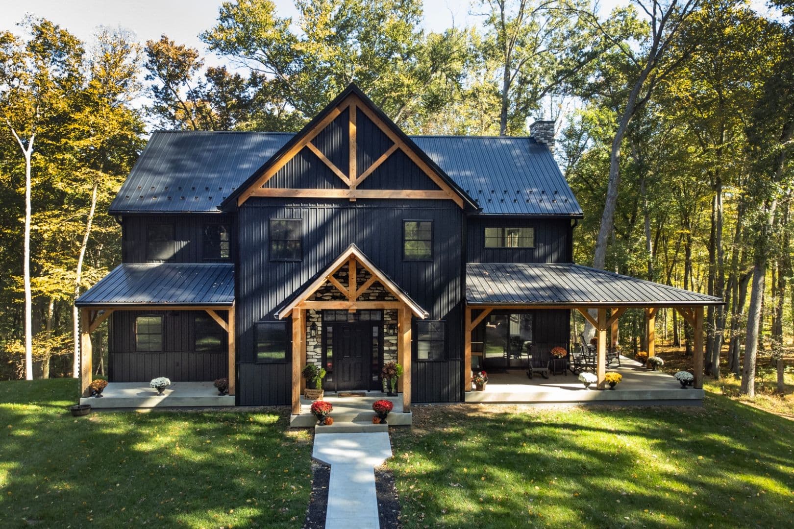 A black new construction barndominium with light brown wood accents.