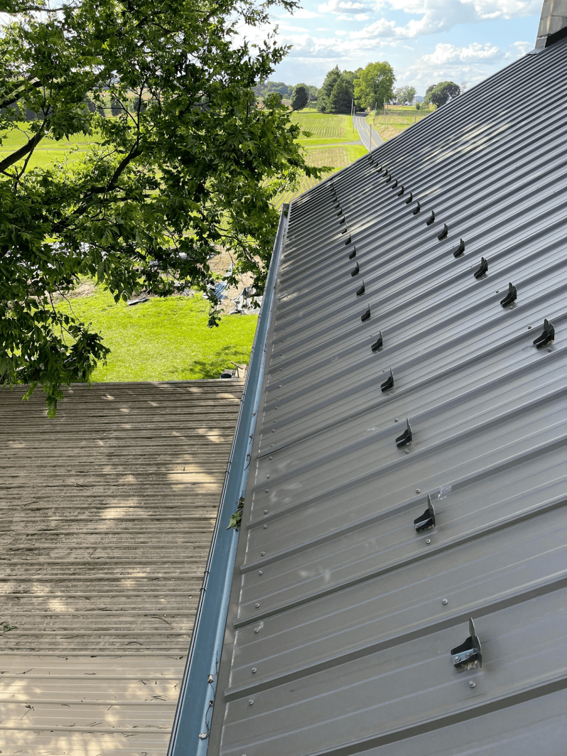 A roof-level close up view of newly-installed gray metal roofing.