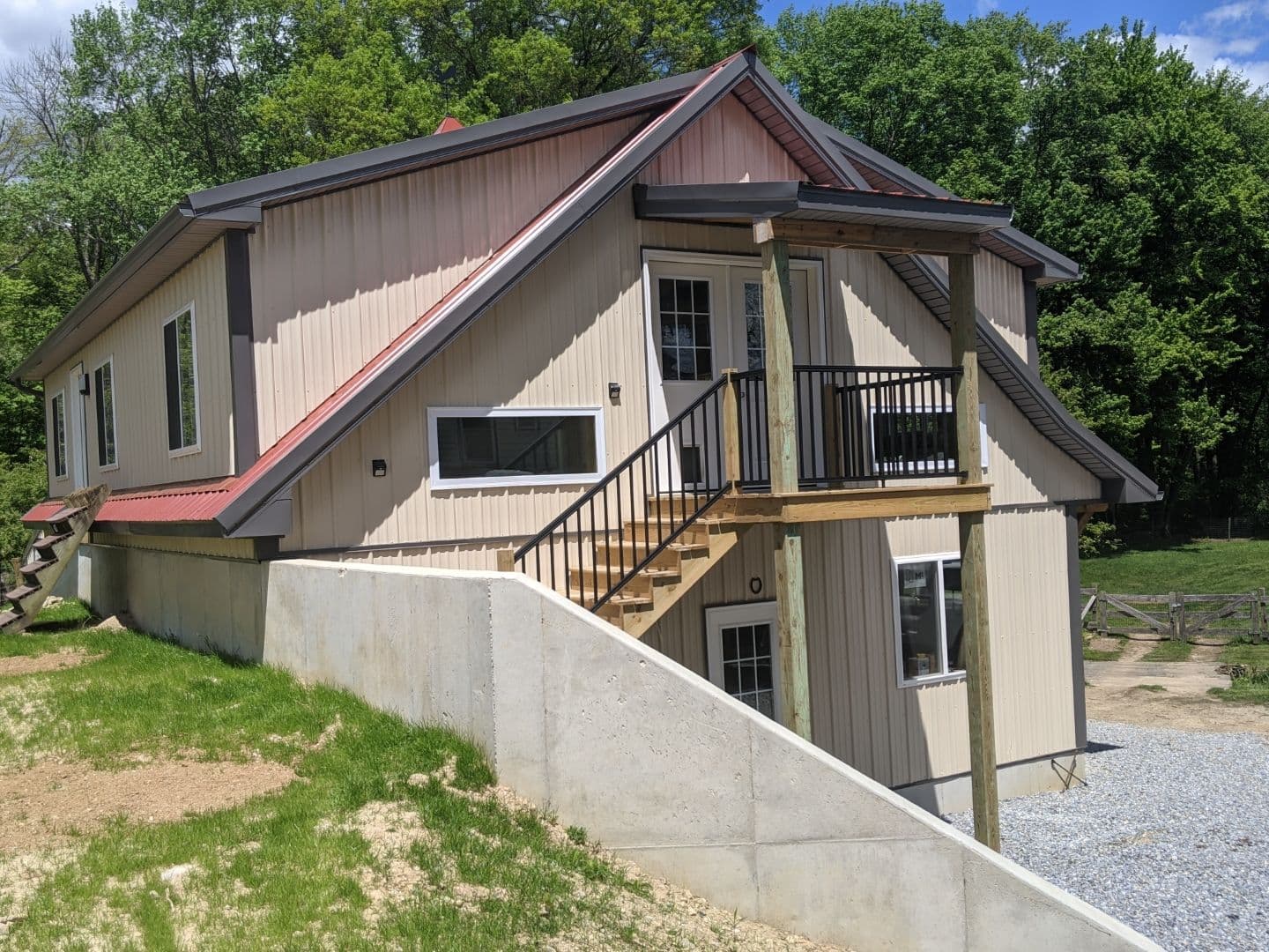A light-colored pole building with a red roof.
