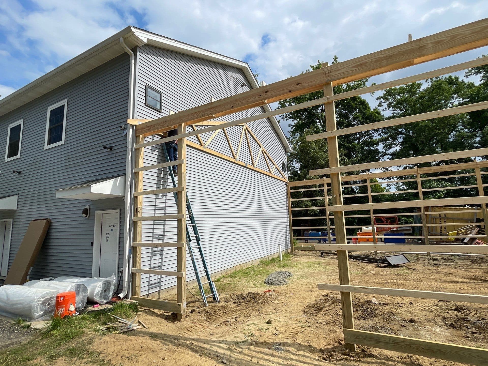 A post frame addition to a house being built.