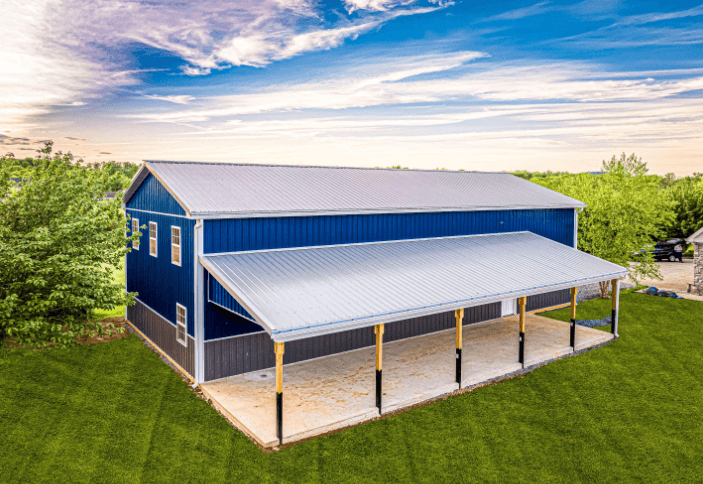 A blue and gray post frame building with light colored metal roof and large covered area.