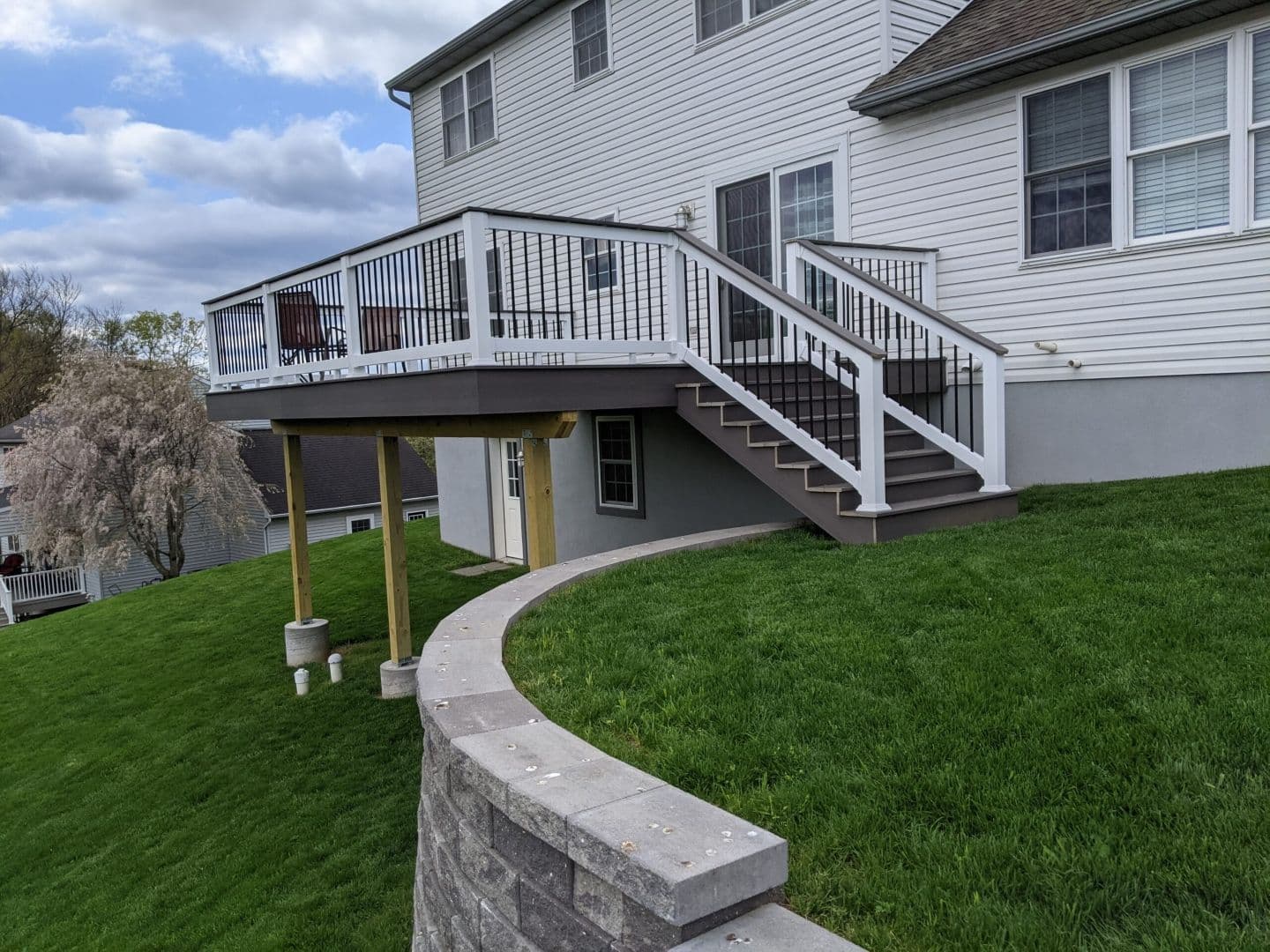 A deck over a yard with a curved retaining wall.