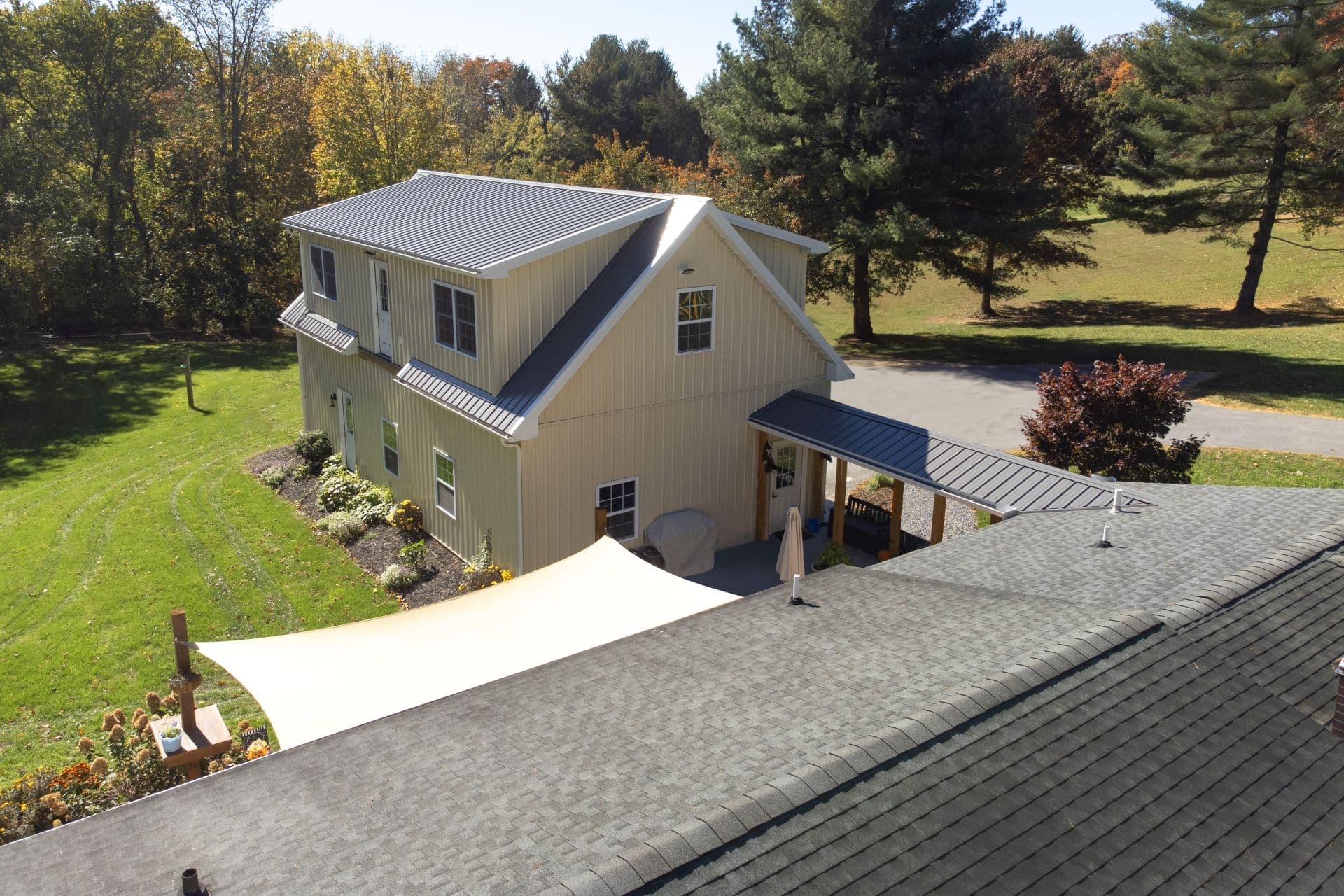 Custom barndominium style pole barn home built by professional pole barn builders with metal roofing and covered outdoor patio.